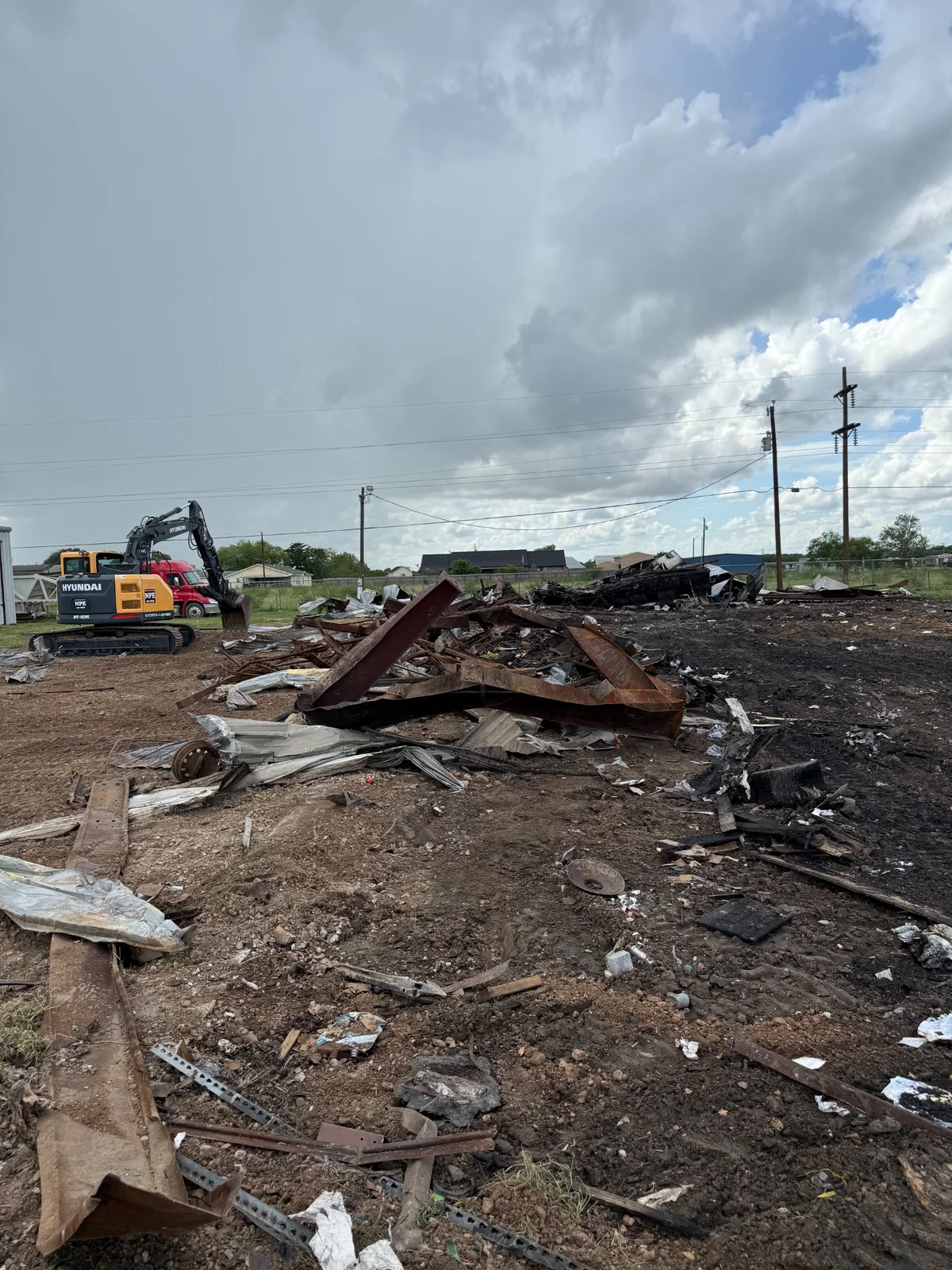 Demolition debris and excavator on cleanup site